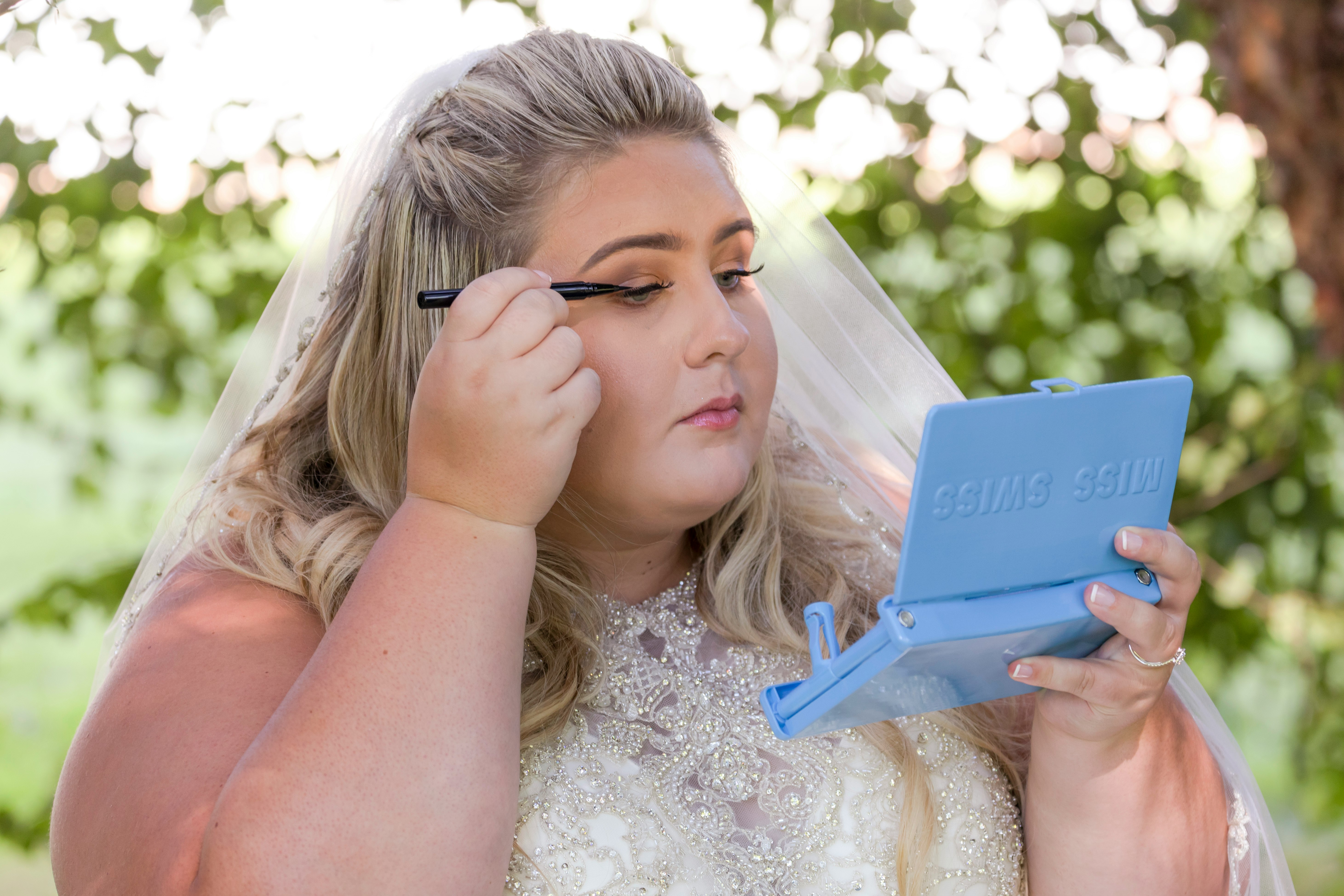 woman in white floral dress holding blue tablet computer